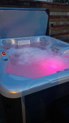 a bath tub filled with pink dye in a bath room at Kincsem Vendégház in Szilvásvárad