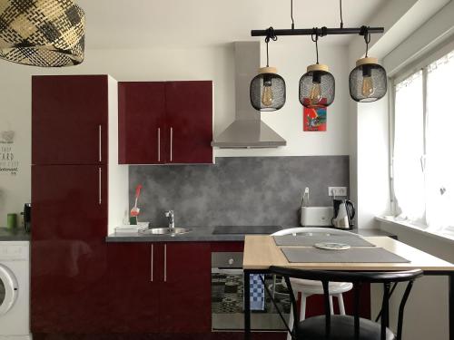 une cuisine avec des armoires marron et un comptoir dans l'établissement Les Bruyeres, à Concarneau