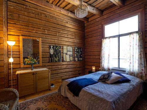 a bedroom with a bed in a wooden room at Koskivaara - vanha koulu - old school in Huutotöyry