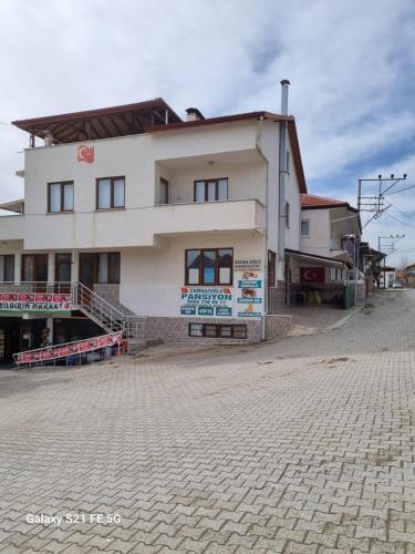 duży biały budynek na ceglanej ulicy w obiekcie Salda Gölüne çok yakın w mieście Yeşilova