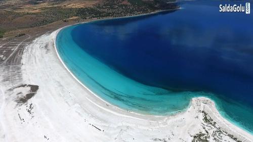 una vista aérea de una playa de agua azul en Salda Gölüne çok yakın, en Yeşilova