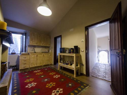 a kitchen with wooden cabinets and a red rug at Casa Della Torre In Borgo Medievale in Stroncone