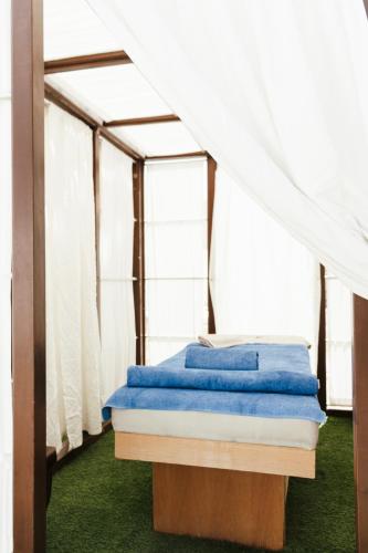 a bed in a tent with blue sheets at Casa Vitae Suites in Kamari