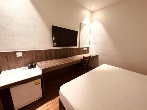 a hotel room with two beds and a tv on the wall at Park View Hotel in Singapore