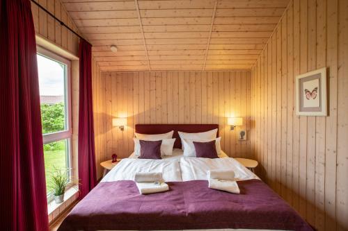 Schlafzimmer mit einem großen Bett und einem Fenster in der Unterkunft Typ F "Holger Ehlers" -Kapitänshaus- in Pelzerhaken