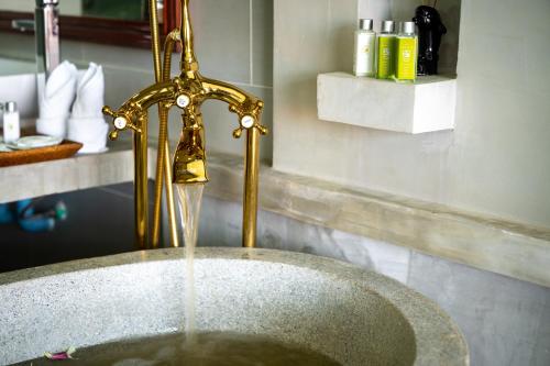 a bathroom sink with water coming out of it at Sala Siem Reap Hotel in Siem Reap
