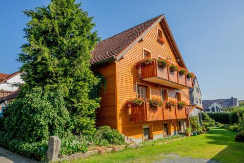 a wooden house with flower boxes on the side of it at Ferienwohnung Schwatlo in Mistelgau