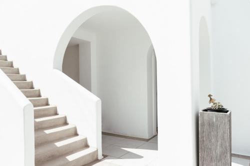 a staircase in a white room with a stair case at Casa Vitae Suites in Kamari
