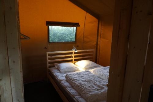 a small bed in a room with a window at Camp Hverringe in Dalby