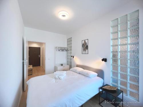een slaapkamer met een groot wit bed in een kamer bij Vistula Riverside Apartment in Krakau