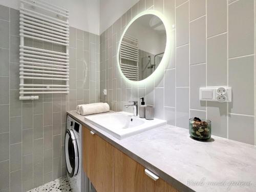 een badkamer met een wastafel en een spiegel bij Vistula Riverside Apartment in Krakau