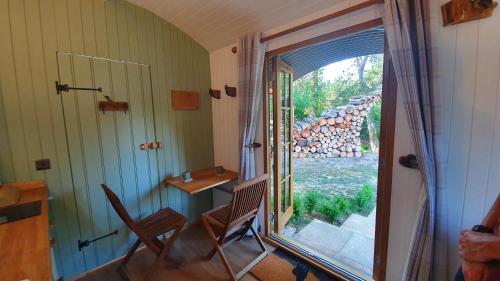 a room with a window and two chairs and a table at Sika hut in Wareham