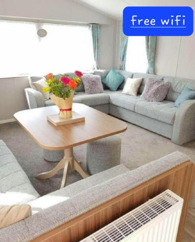 a living room with a couch and a coffee table at Lake District 2021 Deluxe Static Caravan on Haven Lakeland in Flookburgh