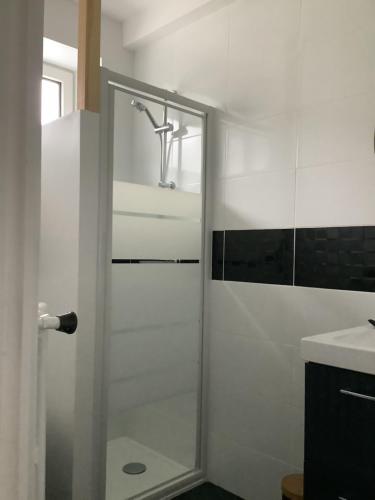 a shower with a glass door in a bathroom at Les Bruyeres in Concarneau