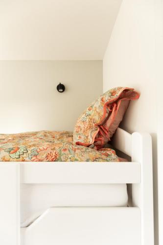 a bed with a pillow on top of it at de Zuiderstolp in Zuidermeer
