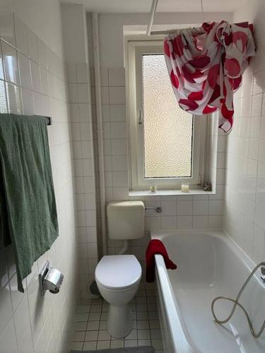 ein Bad mit einem WC, einer Badewanne und einem Fenster in der Unterkunft Quet Room in 3 bedrooms flat,3 min to Metro, free parking,Supermarket near in Frankfurt am Main