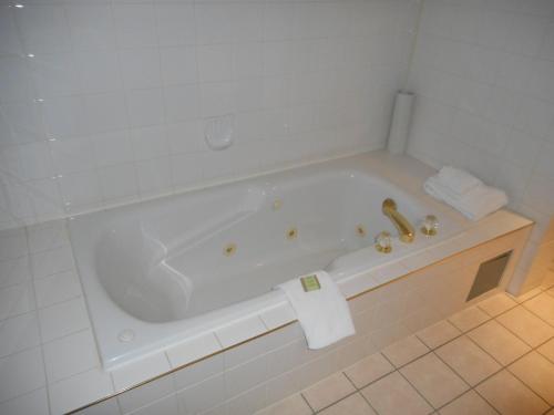 a white bath tub in a bathroom at Super 8 by Wyndham Fox Creek in Fox Creek