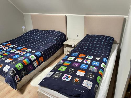 two beds in a room with an iphone blanket at DOM NA KASZUBACH, SAUNA i BALIA in Nowe Czaple
