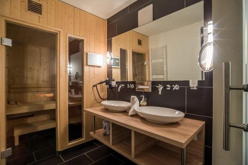 ein Badezimmer mit 2 Waschbecken und einem Spiegel in der Unterkunft Resort Deichgraf Resort Deichgraf 31-01 in Wremen