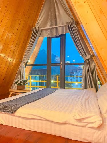 a bed in a room with a large window at Tuong Vi Homestay - Venuestay in Vĩnh Phúc