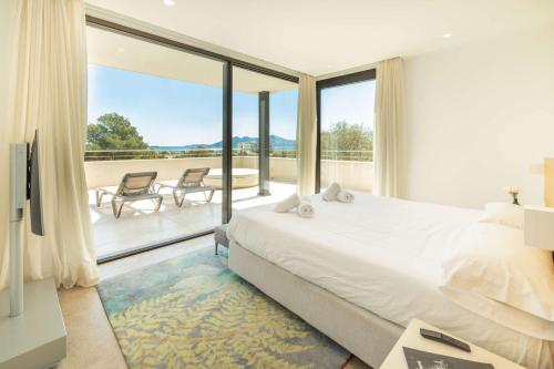 a bedroom with a large bed and a balcony at Villa Marvelo in El Port