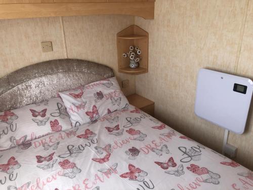 a bedroom with a bed with pink butterflies on it at Sws Coral Beach 3 bedroom sleeps 6 in Ingoldmells
