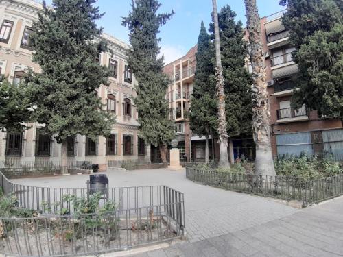 a courtyard with trees and a fence in front of a building at APARTAMENTO PATRICIA in Murcia
