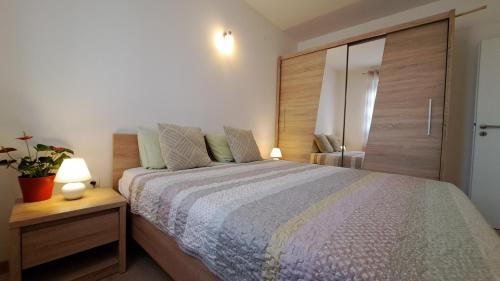 1 dormitorio con 1 cama grande y cabecero de madera en Holiday apartman, en Kaštela