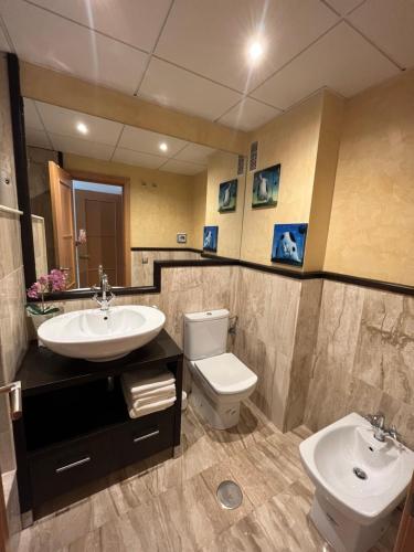 a bathroom with a sink and a toilet and a mirror at Altos del Toril 2 habitaciones Wifi y Parking in Torremolinos
