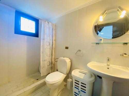 a bathroom with a toilet and a sink and a mirror at Meltemi rock house in Kalandra