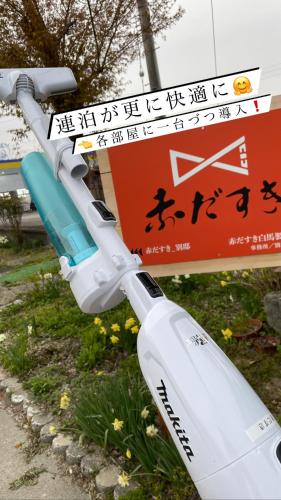 a street sign with a white object next to a sign at 赤だすき_別邸 in Hakuba