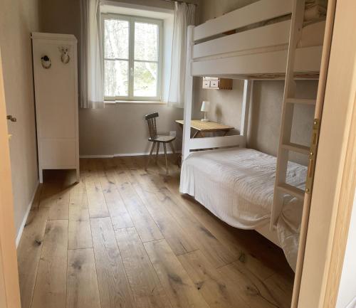 a bedroom with bunk beds with a desk and a window at il peperino in Castel del Piano