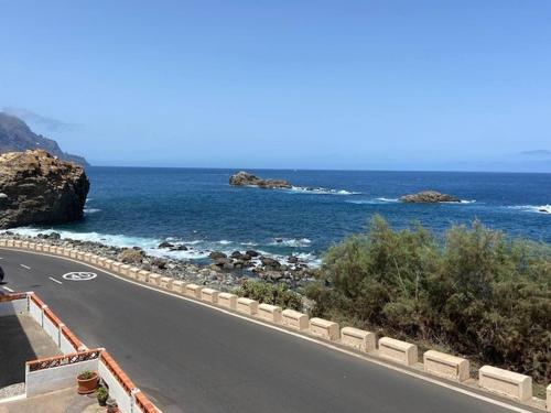 a road next to the ocean with rocks and water at Cosy twin beds La Baja in Santa Cruz de Tenerife