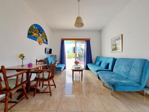 a living room with a blue couch and a table at Florence Hotel Apartments in Ayia Napa