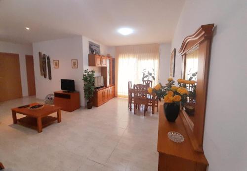 a living room with a vase of flowers on a table at MAR DE OROPESA DREAMS PLAYA DE LA CONCHA in Oropesa del Mar