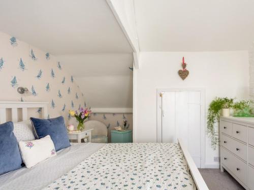 um quarto com uma cama com pássaros azuis na parede em Rose Cottage em Stoke Fleming