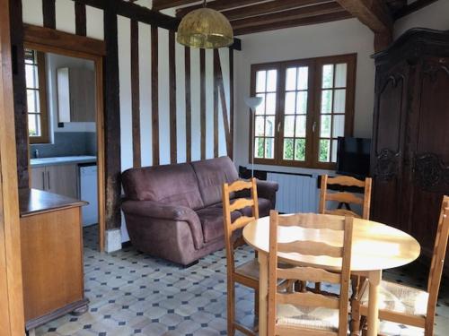 ein Wohnzimmer mit einem Sofa, einem Tisch und Stühlen in der Unterkunft le colombier de Royaumont in Saint-Arnoult