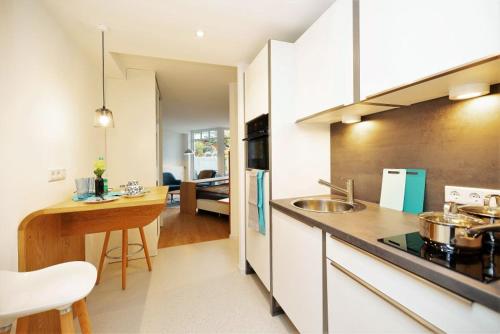 a kitchen with a counter top and a kitchen with a table at ArtRoom Boarding Apartment in Bissendorf