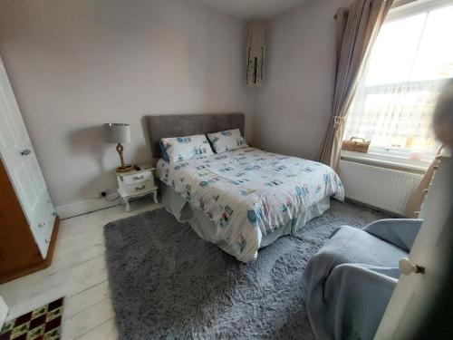 a small bedroom with a bed and a window at Dune Cottage in Caister-on-Sea
