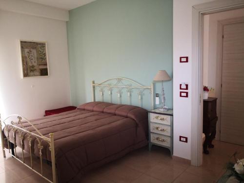 um quarto com uma cama e uma cómoda com um candeeiro em Da Alduccio em Vico del Gargano