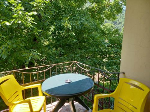 a blue table and yellow chairs on a balcony at Hotel Villa Borjomi in Borjomi