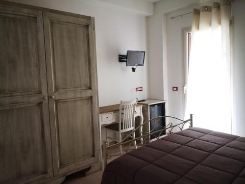 a bedroom with a bed and a desk and a tv at Da Alduccio in Vico del Gargano