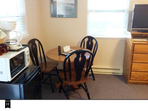 a kitchen with a table with four chairs and a microwave at Ecola Creek Lodge in Cannon Beach
