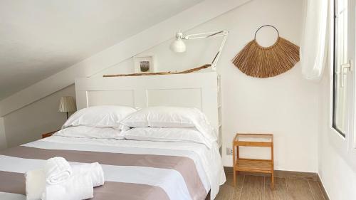 a white bedroom with a white bed with white sheets at Villa Arcipelago in Cefalù