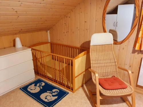 a room with a crib and a chair at Ferienhaus "Seelöwe Baabe" in Baabe