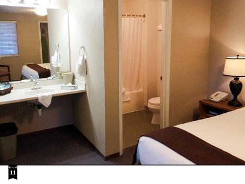 a bathroom with a bed and a sink and a toilet at Ecola Creek Lodge in Cannon Beach