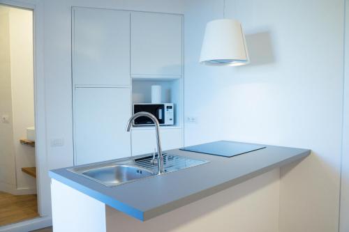 a kitchen counter with a sink and a lamp at La Terrazza sui Bastioni in Alghero
