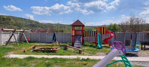 un parque infantil con un juego de juegos y un tobogán en POARTA SOARELUI, en Teliucu Inferior