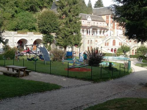 un parque con parque infantil frente a un edificio en Appartement rue de la cascade 64440 Eaux-Bonnes, en Eaux-Bonnes