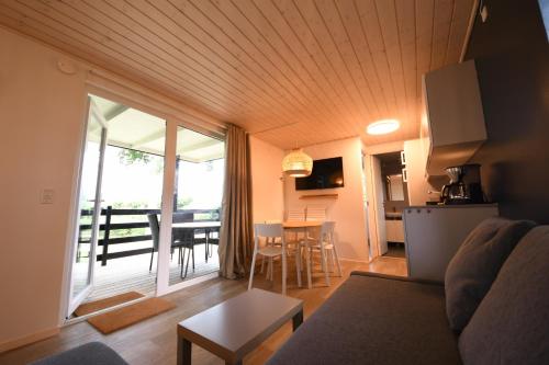 a living room with a couch and a kitchen and a table at Camp Hverringe in Dalby